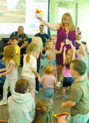 KAYLA BAINBRIDGE incites cheer before Storytime begins.