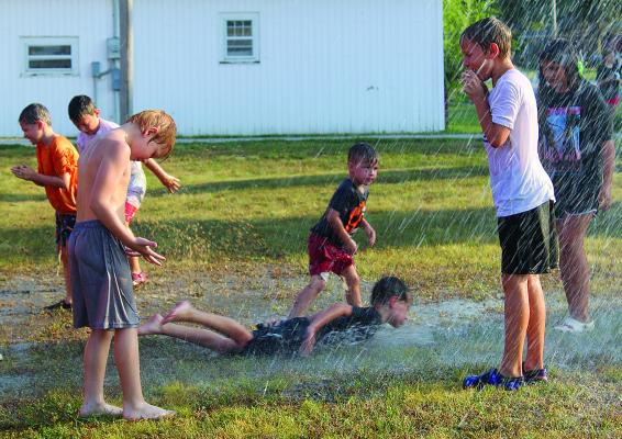 ORRICK CHILDREN play in a mud puddle while being sprayed with hoses by the Orrick Fire Department. MIRANDA JAMISON | Staff