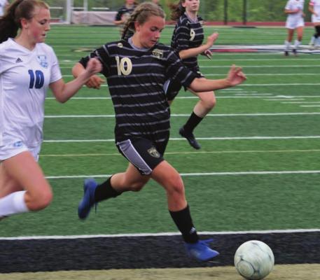 FRESHMAN ABBY RASH dribbles into the 18-yard box, looking to score for Excelsior Springs.