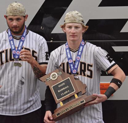 EXCELSIOR SPRINGS BASEBALL TEAMMATES Brody Querry (left) and Cooper Collins sport their Class 4 state championship medals after exiting the Tigers’ charter bus. SHAWN RONEY | Staff