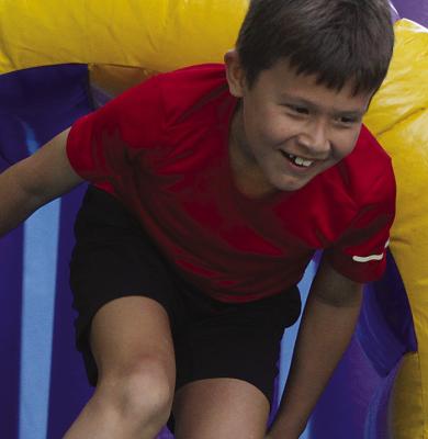 SHARON DONAT | Staff EASTON HASELEA darts through a bounce house tunnel.
