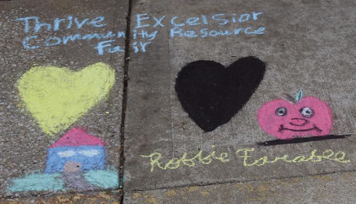 ROBBIE FARABEE creates chalk art to welcome attendees to the Thrive Excelsior Community Resource Fair. MIRANDA JAMISON | Staff