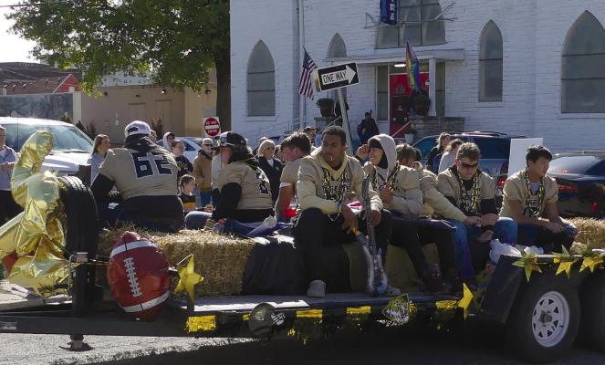 ELIZABETH BARNT | Staff HIGH SCHOOL football players ride on a trailer through the parade.