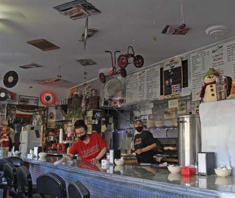 AT RAY’S LUNCH, Natasha Prewitt cleans the counter while her mother, restaurant owner Brenda Fudge, waits for a breakfast order to come up from the kitchen. Some of the fixtures in the Excelsior Springs restaurant date to the opening in 1932. J.C. VENTIMIGLIA | Staff