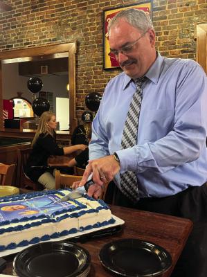 FORMER PUBLISHER of the Richmond News and Excelsior Springs Standard Brian Rice cuts his retirement cake. Rice has begun a new journey as president of the Excelsior Springs Area Chamber of Commerce. SOPHIA BALES | Staff