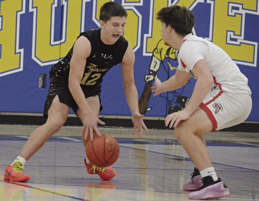 OWEN O’DELL (left), an Excelsior Springs sophomore, looks to dribble past Richmond’s Dryden Hendrix during the Husker Classic. SHAWN RONEY | Staff