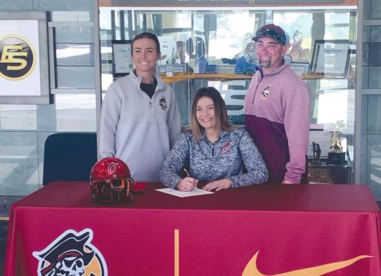 SENIOR AVORY MOORE signs her letter of intent to play NAIA softball with Park University head coach Lindsey Derry and assistant coach Tony Austin behind her. DUSTIN DANNER | Staff