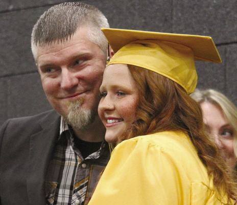 EXCELSIOR SPRINGS Board of Education member Darren McKown congratulates Abby Gallaway after presenting her diploma. MIRANDA JAMISON | Staff