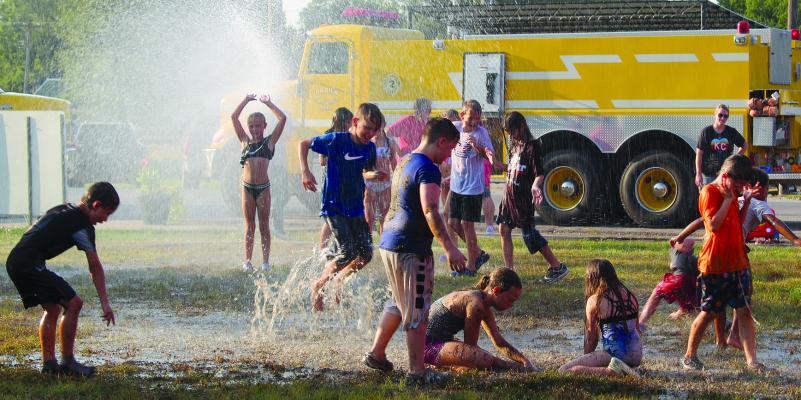 LOCAL CHILDREN of all ages have fun in water and mud puddles hosted by Orrick Lions Club and Fire Department at a back-to-school fun night. MIRANDA JAMISON | Staff