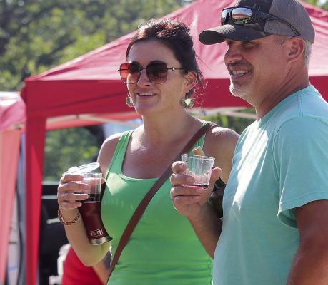 MIRANDA JAMISON | Staff SAMANTHA BALLEW (left) and Lucas Conley visit with festival vendors and enjoy samples.
