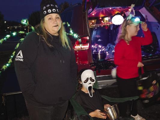 LINDSAY HALL (left) and Aislee Nickel (center) hand out Halloween candy during Beacon Reality’s Trunk-or-Treat event. MIRANDA JAMISON | Staff