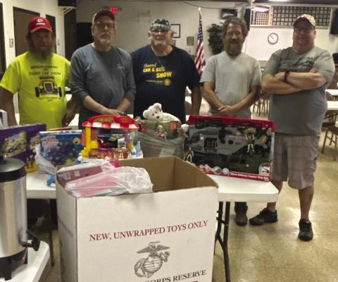RUSTY HARRINGTON (from left), Rodney Holt, Larry Kerr, Chris Stull and Brock Stout stand behind table of toys collected for children in need. CHRIS STULL | Submitted