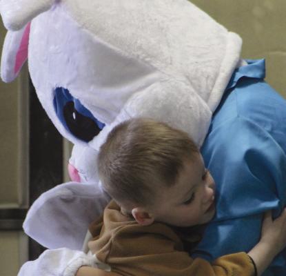 MERRIT PIGG wraps the Easter Bunny in a tight hug during Wood Heights Fire Protection District’s Easter Egg hunt. SHARON DONAT | Staff