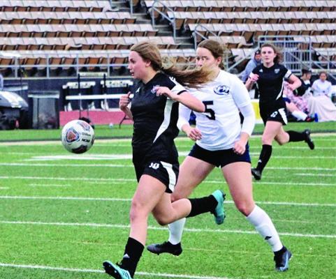 EXCELSIOR SPRINGS junior Abby Rash shields the ball and races past a William Chrisman defender en route to scoring a goal during the Tigers’ 4-2 March 30 home loss. DUSTIN DANNER | Staff