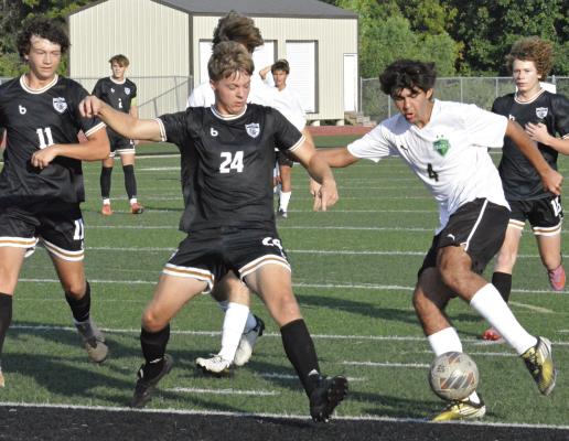 EXCELSIOR SPRINGS SENIOR Cruz Lloyd (left) watches as teammate Isaiah Ishmael (center) challenges The Barstow School’s Ivan Caballero Vieyra in the Tigers’ 18-yard box during tournament play. SHAWN RONEY | Staff