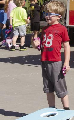 OLIVER SULLIVAN lines up a throw in a game of cornhole at the Wheels of Engagement event.