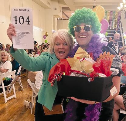JAKE SIMMONS (RIGHT) PRESENTS the basket of goodies to winning bidder Monica Shane. MONICA SHANE | Submitted