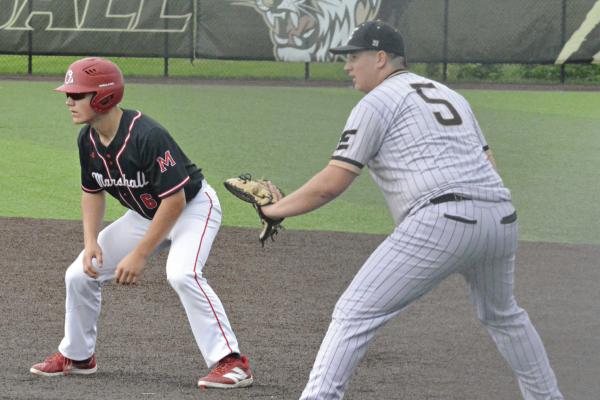 HIS GLOVE outstretched, Brayden Lewis looks to hold Marshall’s Hayden Igo to first base.