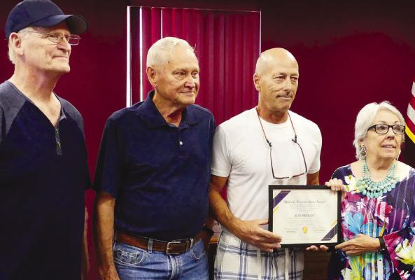 Arlo Rosenboom (from left), Ed Emery and Ron Prewitt accept the Historic Preservation Award from Betty Bissell. ELIZABETH BARNT | Staff