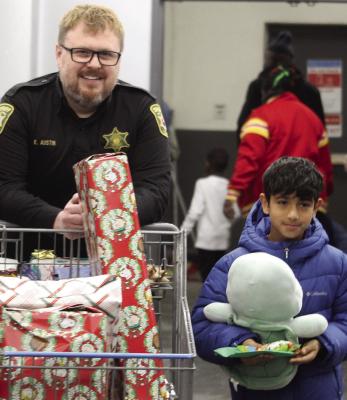 DETENTION OFFICER KEVIN AUSTIN (left) shops alongside Sameer Rasooli during the Clay County Shop with a Sheriff event. MIRANDA JAMISON | Staff