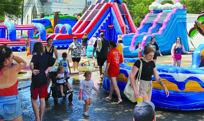 KIDS HAVE A blast staying cool by zipping down waterslides and work up a frenzy inside bouncy houses. The family fun was made possible through sponsorships from Lakeside Bounce, Tray Harkins Flat Branch Loans and REMAX Manley Home Team at the festival.