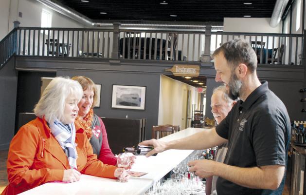 TONYA WATSON (from left) and Kelli Gooding sample wine and chocolate mousse at Pairings by Van Till. Owner Cliff Van Till and General Manager Jason Van Till explain how pairing wine with the mousse brings out the undertones of the chocolate. KAYLA BREWER-CLEMENTS | Staff