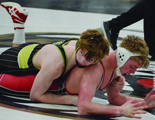 EXCELSIOR SPRINGS SENIOR Cooper Collins (left) appears to glance toward the scorer’s table as he holds down Odessa’s Kamden Hooper during the 144-pound title match at the Class 2 District 4 boys wrestling competition. SHAWN RONEY | Staff