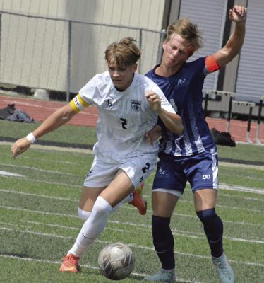 SENIOR BRADY SCHOONOVER (right) stays with the ball and fights to maintain his balance while being challenged during Excelsior Springs’ jamboree scrimmage with Faith Christian Academy. SHAWN RONEY | Staff