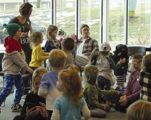 CHILDREN AND THEIR parents gather to play and listen to stories being read by local heroes. ELIZABETH BARNT | Staff