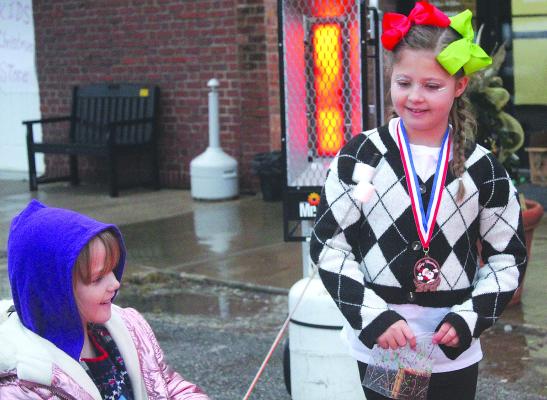 JOSIE GOWING (right) helps Aurora Taff make smores during the Christmas festivities. MIRANDA JAMISON | Staff