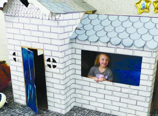 MADDIE VASSMER has fun in the playhouse, one of several play stations set up for the kick-off event. ELIZABETH BARNT | Staff