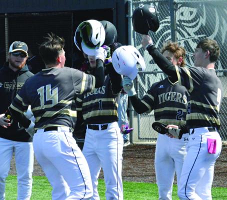 JAXTON GLASPY (front, left) exchanges helmet bumps with (from left) Cooper Collins, Landon Clark and Spence Gibbs after swatting a bases-loaded homer during the second game of Excelsior Springs’ doubleheader with Benton, a St. Joseph-based school. SHAWN RONEY | Staff