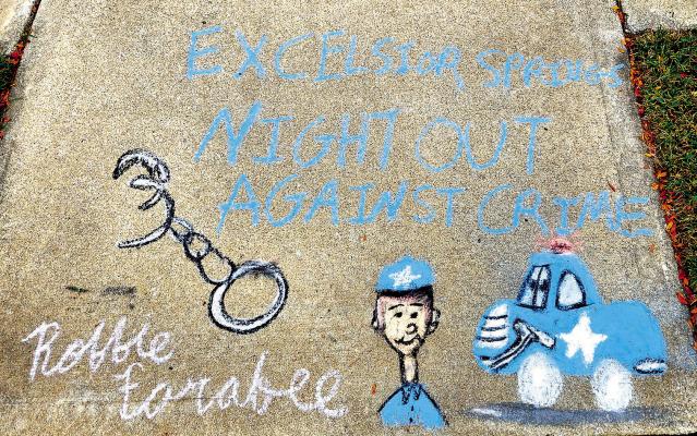 MIRANDA JAMISON | Staff ROBBIE FARABEE designs chalk art for Excelsior Springs Night Out Against Crime.
