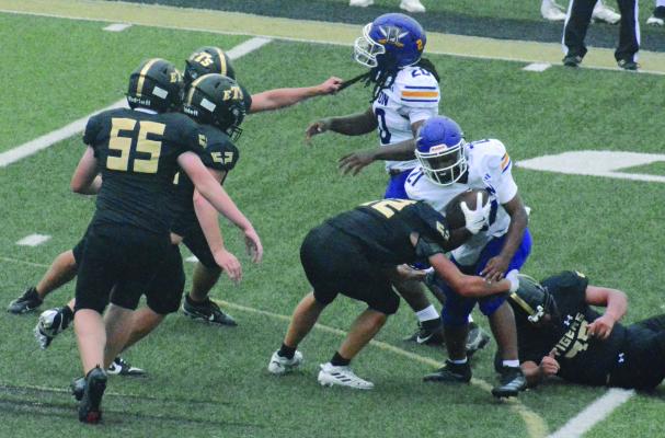 AN AMBUSH of Tigers swarms to the football during Excelsior Springs’ junior varsity meeting with Belton in 11-man football. The Labor Day clash at Tiger Stadium followed Excelsior Springs’ varsity season opener at Belton. For coverage of the varsity squad, see page 7. SHAWN RONEY | Staff