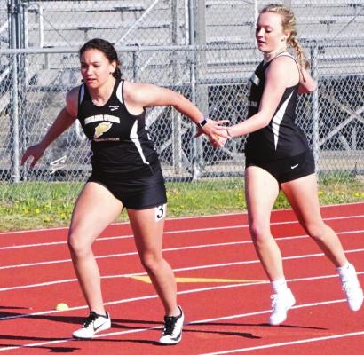 EXCELSIOR SPRINGS sophomore Alani Price reaches back to grab the relay baton from first-year high schooler Maddie Green in the girls 400-meter relay April 14 during the Highway 92 Meet at Tiger Stadium. DUSTIN DANNER | Staff