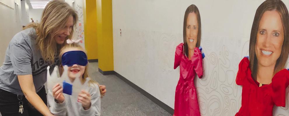 SPECIAL EDUCATION TEACHER Lisa Walter (left) helps students play a game of pin the crown on Principal Dr. Jill Comstock. MIRANDA JAMISON | Staff