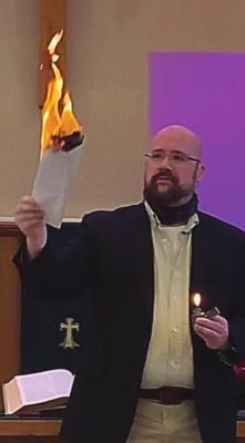 PASTOR John Dearing ceremonially burns a copy of the church mortgage, which members paid off.