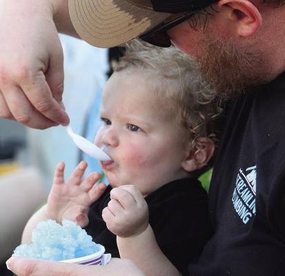 SAWYER WILSON COOLS off with shaved ice alongside his father, Billy, during Excelsior Springs’ 2026 Waterfest. MIRANDA JAMISON | Staff