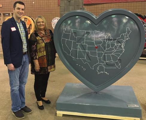 EXCELSIOR SPRINGS has a heart, as rendered by artist Blake Bryant, who stands beside Mayor Sharon Powell at the art heart unveiling at Hale Arena at the American Royal in Kansas City.