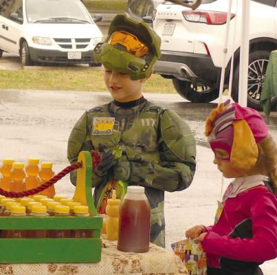 ZANDER (LEFT) AND Kinsley Spohn collect candy during the market’s fall festivities.