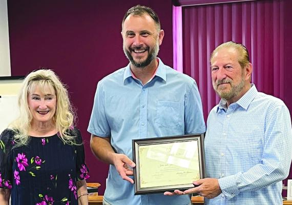 JOHN AND JILL CLARK receive a residential preservation award from Jason Van Till (center) for their work revitalizing a historic home on South Kansas City Avenue.