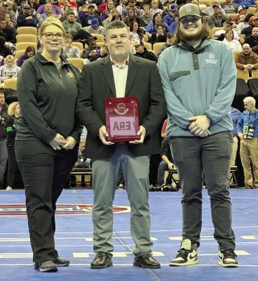 EXCELSIOR SPRINGS ACTIVITIES DIRECTOR Joe Greim displays his MSHSAA Distinguished Service Award in February during state wrestling competition, flanked by his wife Vickie and son Corey. DUSTIN DANNER | Staff