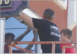 Brad Wehmer and Mark Mast working together to replace old wood trim on the front of the building to enhance the street view and prevent future damage to the building. ELIZABETH BARNT | Staff