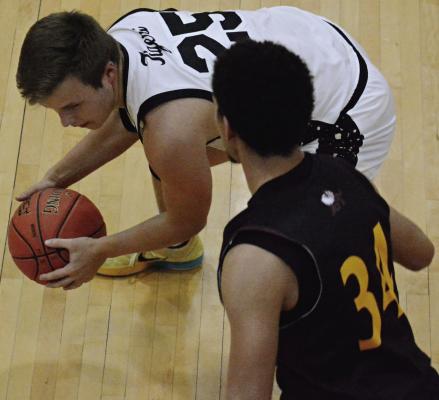 EXCELSIOR SPRINGS junior Brett Jones keeps both hands on the basketball as he looks to drive on Winnetonka’s Antonio Fowler. SHAWN RONEY | Staff