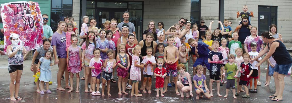 THE CHILDREN WHO attended the Messy Mania event smile after painting a thank you sign for those who sponsored Parks and Recreation Month celebrations. MIRANDA JAMISON | Staff