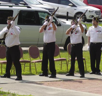 THE HONOR GUARD presents its arms and fires volleys to commemorate the Memorial Day ceremony.