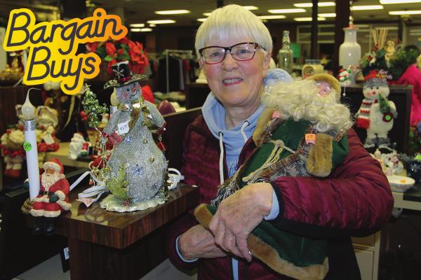 MUSEUM VOLUNTEER Mary Miller displays some of the items up for sale in the expansive holiday section of the rummage sale Saturday, the final day of the five-day fundraising event to benefit the museum.