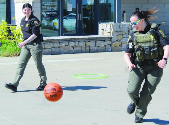 DETENTION OFFICER Madison Sailer (left) and Deputy Amber Brashear chase down a basketball while taking part in games with attendees.