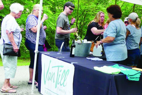 VAN TILL WINERY shares samples of wine with guests.