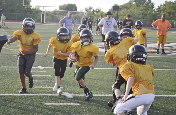 PARKER WAINSCOTT of the Excelsior Springs Football Association’s fifth-grade team runs through the defense during a practice at Tiger Stadium. DUSTIN DANNER | Staff